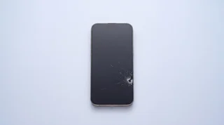 A single iPhone lying on a clean studio surface with its screen dark and asleep
