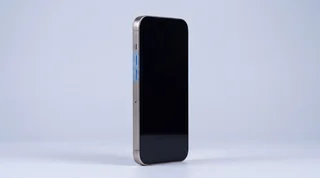 A single iPhone lying on a clean studio surface with its screen dark and asleep