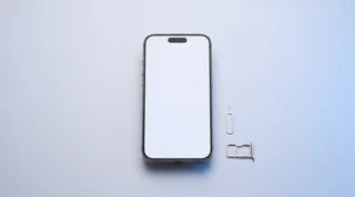 A freshly wiped iPhone with a blank screen and its ejected SIM tray, ready to sell